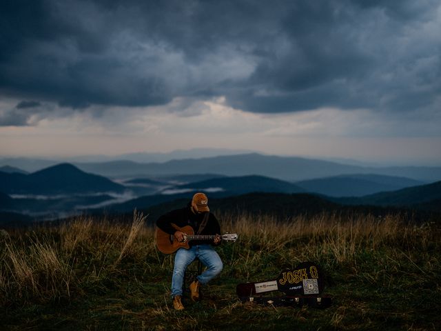 Josh Q playing under a dramatic stormy sky in the mountains