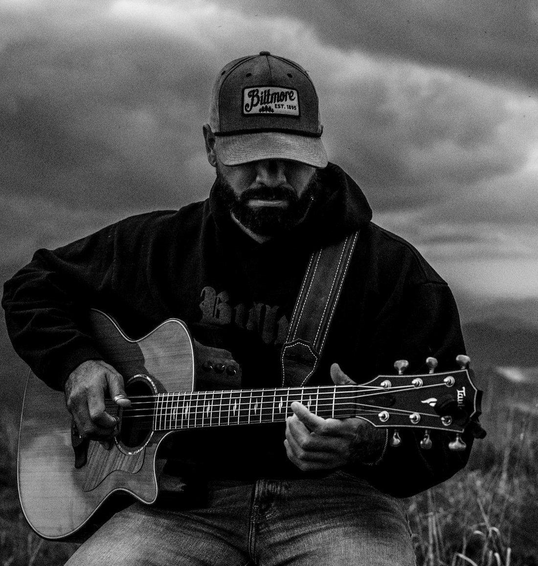 Josh Q with his acoustic guitar at dusk in the Blue Ridge Mountains